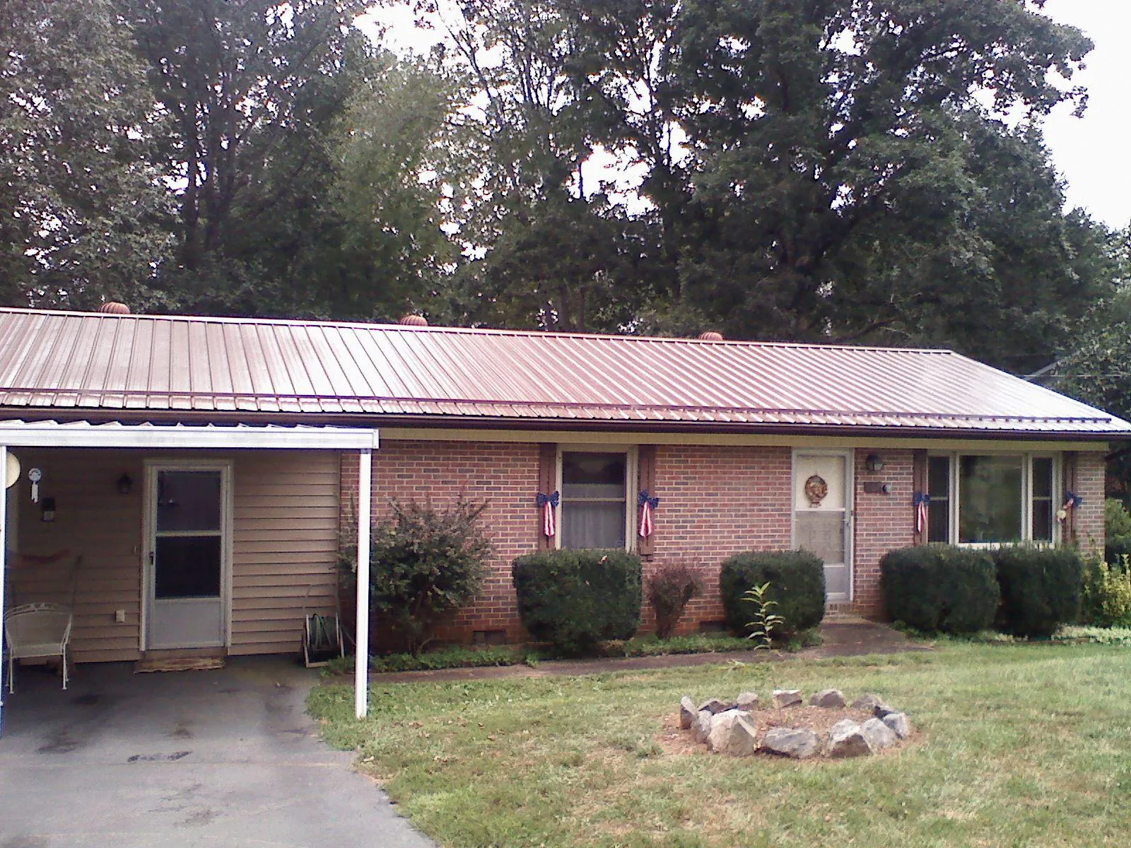 Bronze metal roof and carport on a brick ranch home — Roof Repair work by our crew in Rosedale
