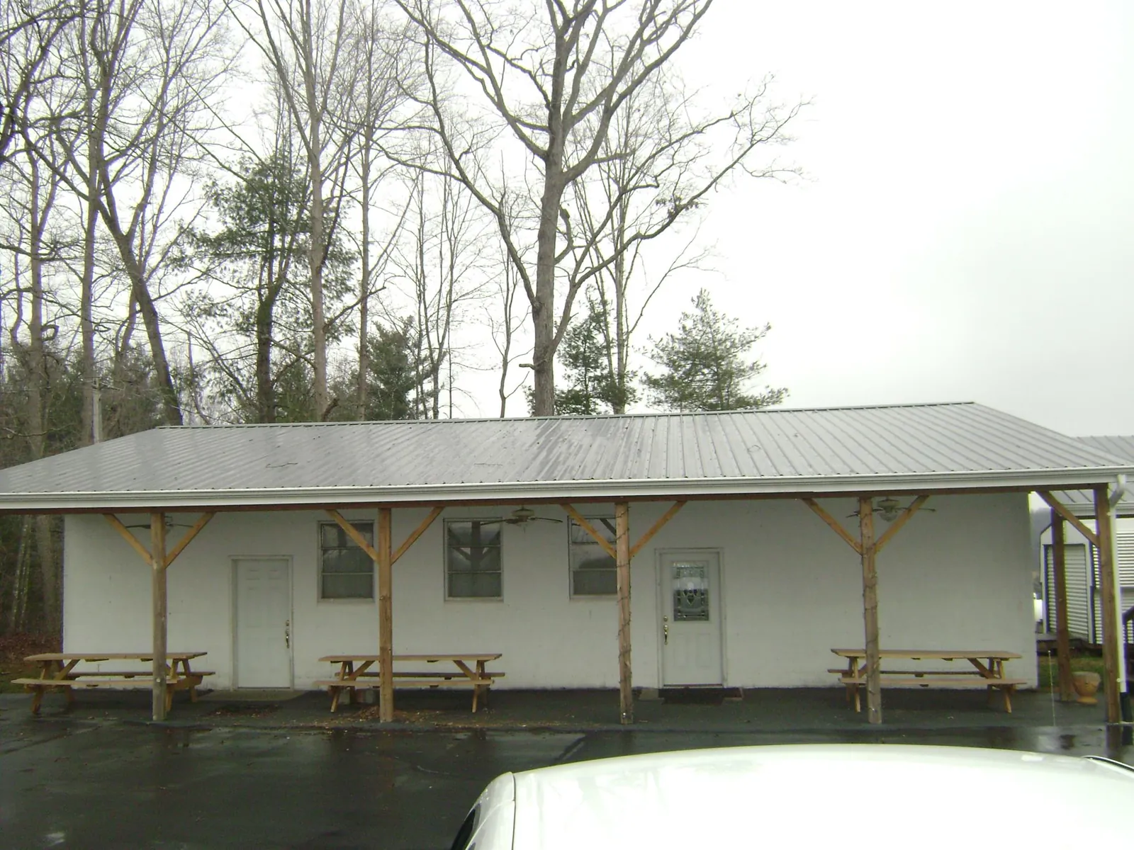 Gray metal roof over a block building with a timber post porch in Rosedale